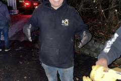 Man in work attire with a novelty crown smiling outdoors at dusk.