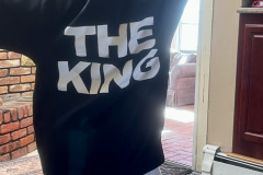 Person in a hoodie with "THE KING" text, standing with back to the camera.