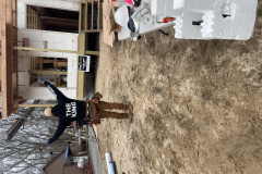 Person with arms raised in front of a construction site wearing "THE KING" hoodie.