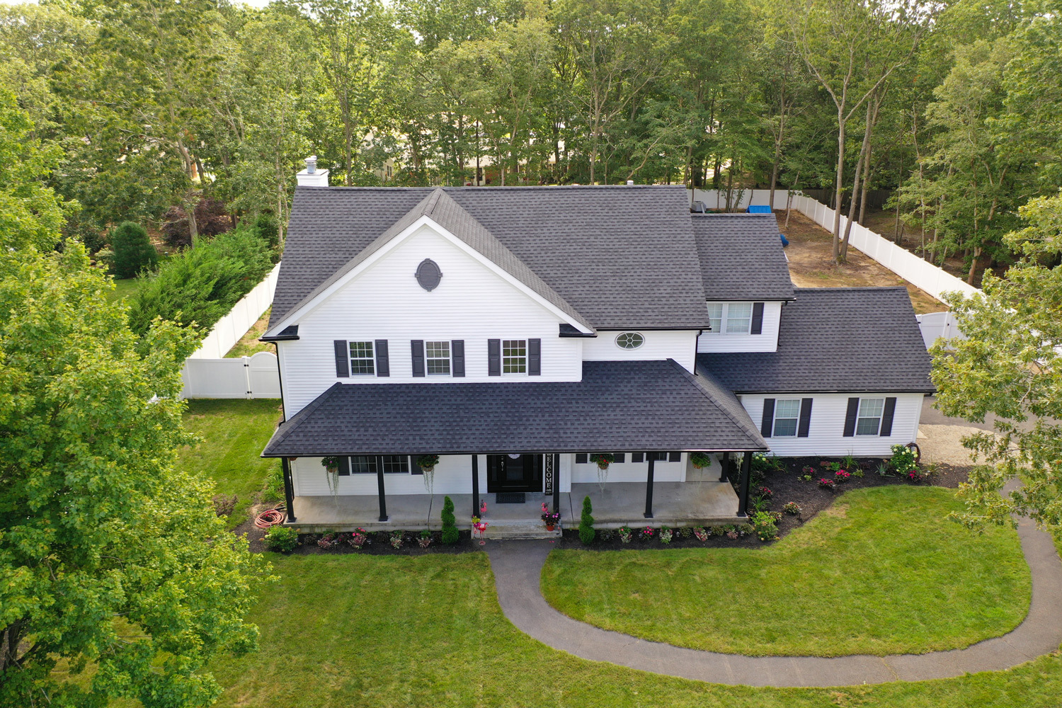 Drone image above house with gray shingles and white siding